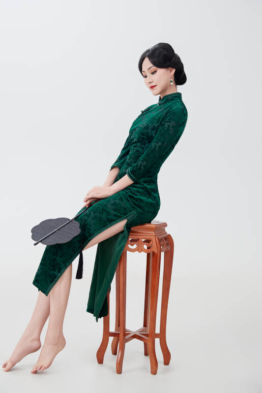 手拿纸扇身着中式旗袍坐在凳子上的美女图片