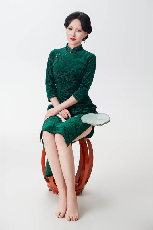 手拿纸扇身着中式旗袍坐在凳子上的美女图片