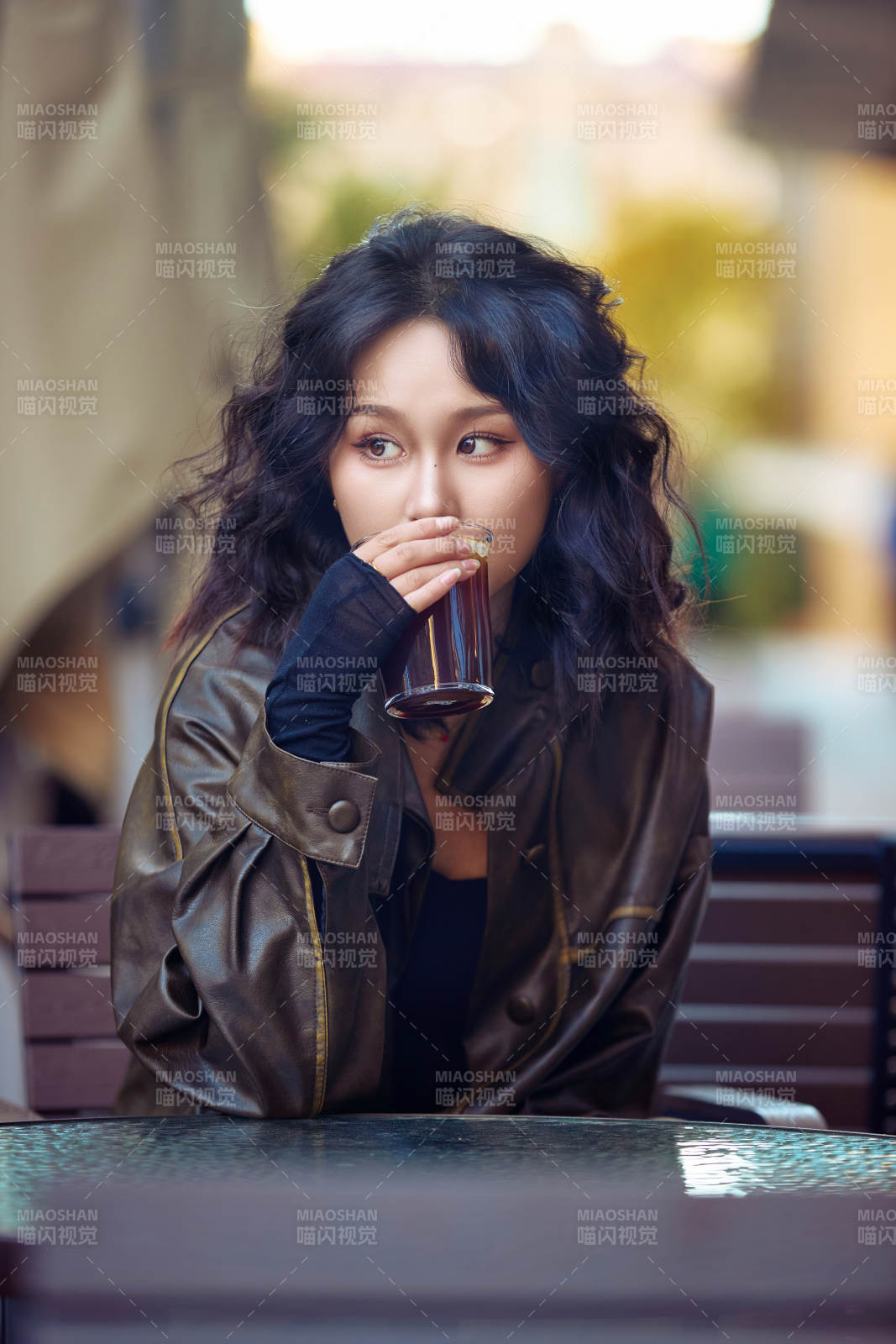 身穿复古皮衣在户外喝咖啡的东方美女图片