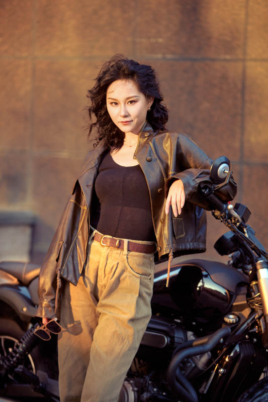 夕阳午后骑复古摩托进行拍照的东方美女图片