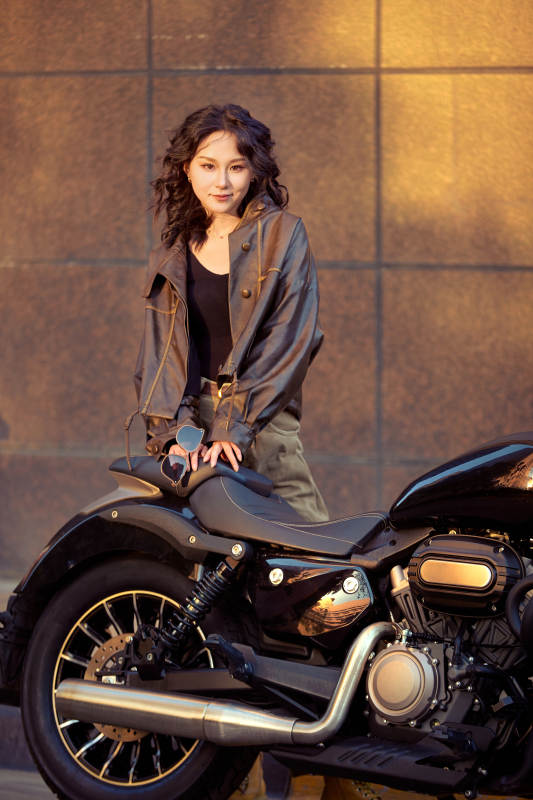 夕阳午后骑复古摩托进行拍照的东方美女图片