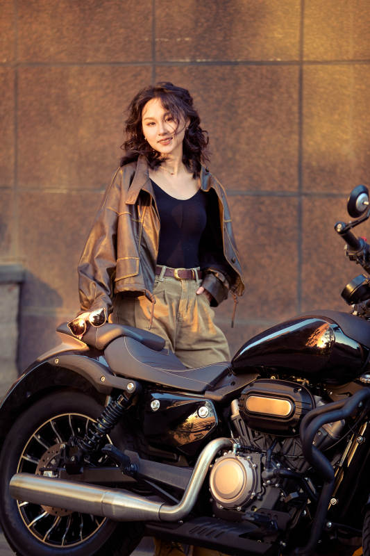 夕阳午后骑复古摩托进行拍照的东方美女图片