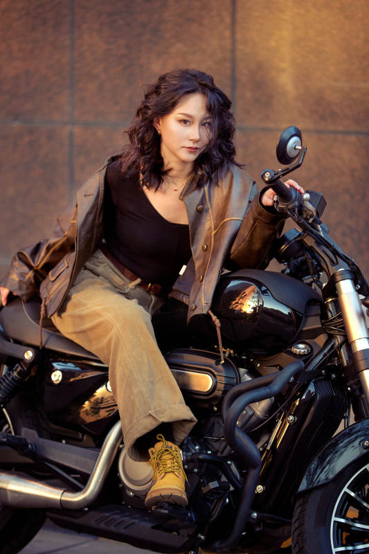 夕阳午后骑复古摩托进行拍照的东方美女图片