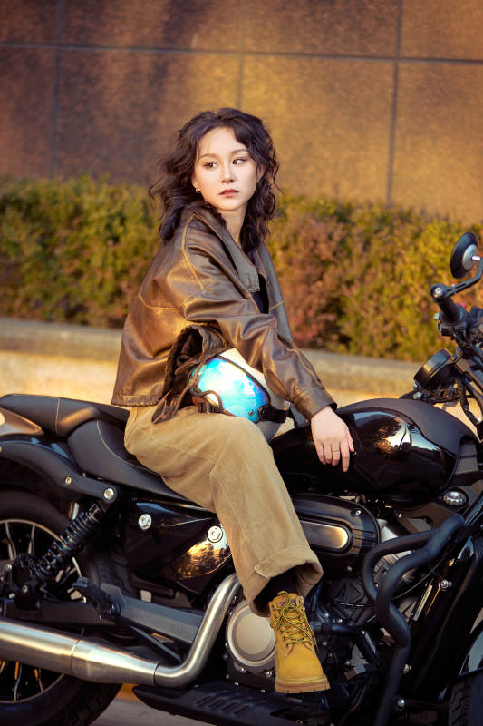 夕阳午后骑复古摩托进行拍照的东方美女图片