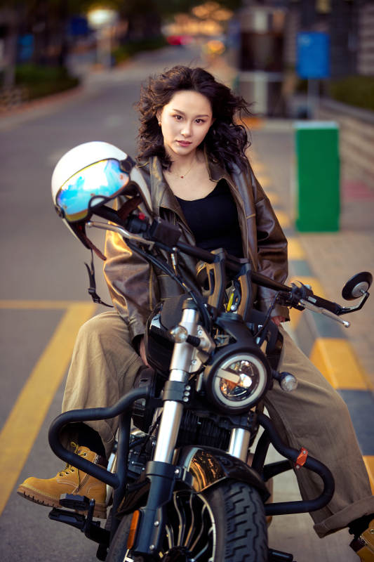 夕阳午后骑复古摩托进行拍照的东方美女图片