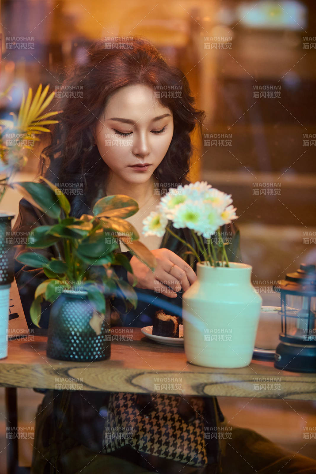 傍晚坐在咖啡店里享受咖啡蛋糕的美女图片