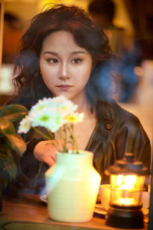 傍晚坐在咖啡店里享受咖啡蛋糕的美女图片