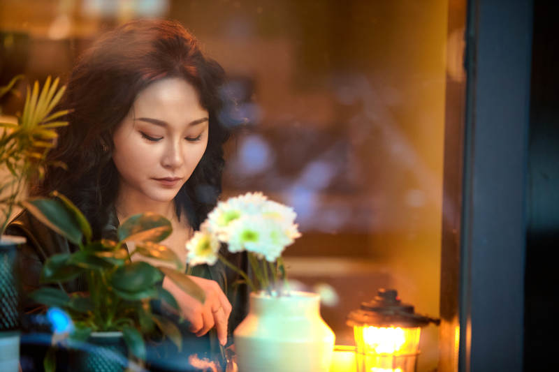 傍晚坐在咖啡店里享受咖啡蛋糕的美女图片