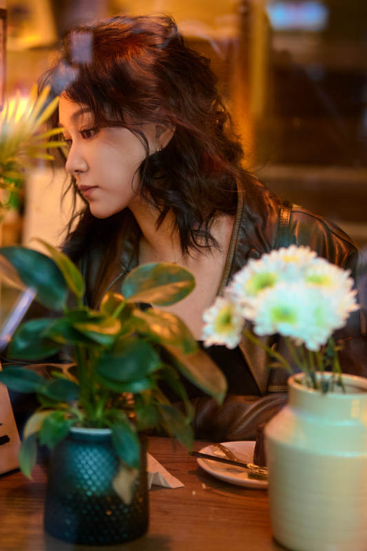 傍晚坐在咖啡店里享受咖啡蛋糕的美女图片