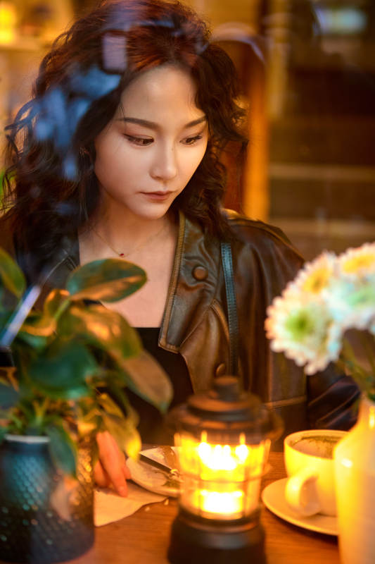 傍晚坐在咖啡店里享受咖啡蛋糕的美女图片