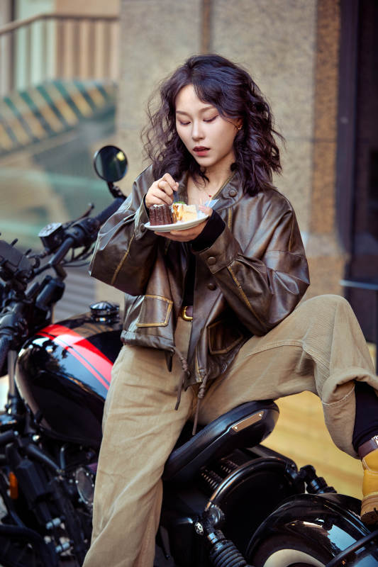 户外在复古机车上品尝甜点的亚洲美女图片