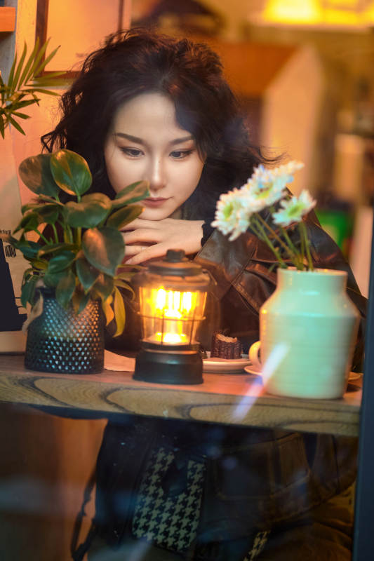 傍晚坐在咖啡店里享受咖啡蛋糕的美女图片