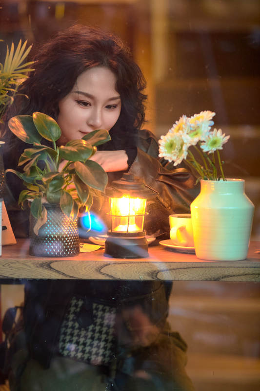 傍晚坐在咖啡店里享受咖啡蛋糕的美女图片