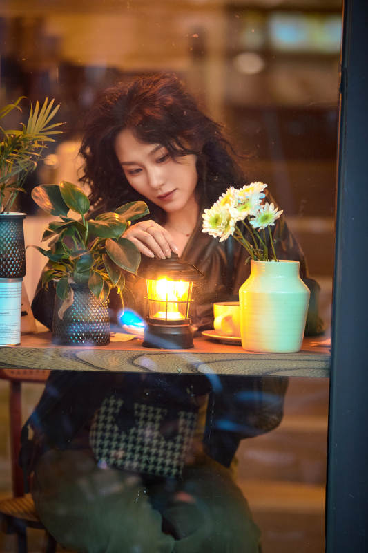 傍晚坐在咖啡店里享受咖啡蛋糕的美女图片