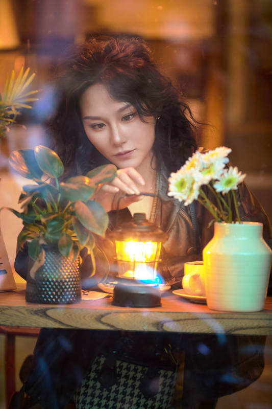 傍晚坐在咖啡店里享受咖啡蛋糕的美女图片