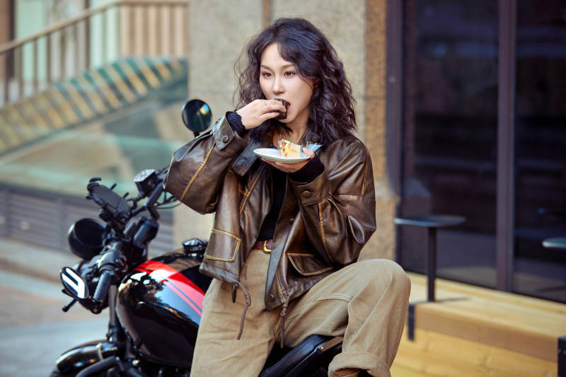 户外在复古机车上品尝甜点的亚洲美女图片