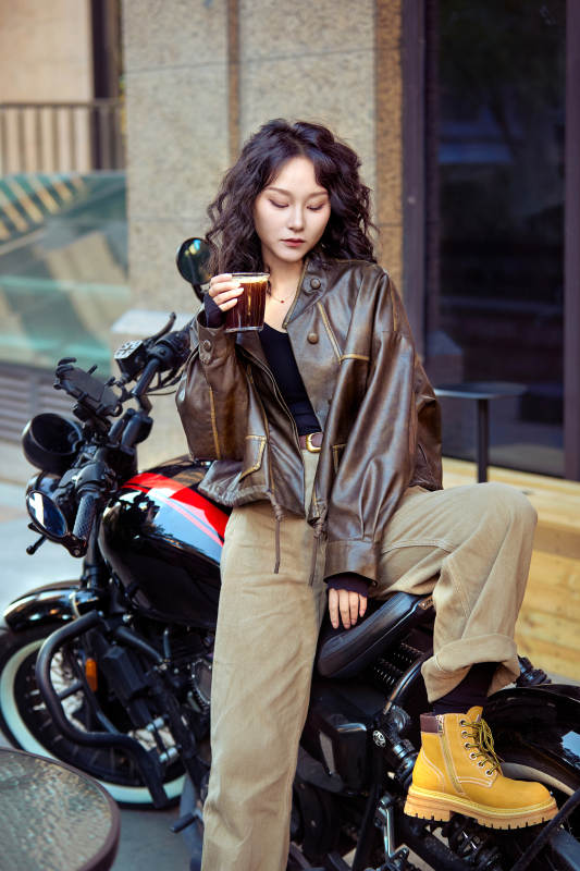 手拿冰美式咖啡坐在摩托上的亚洲美女图片