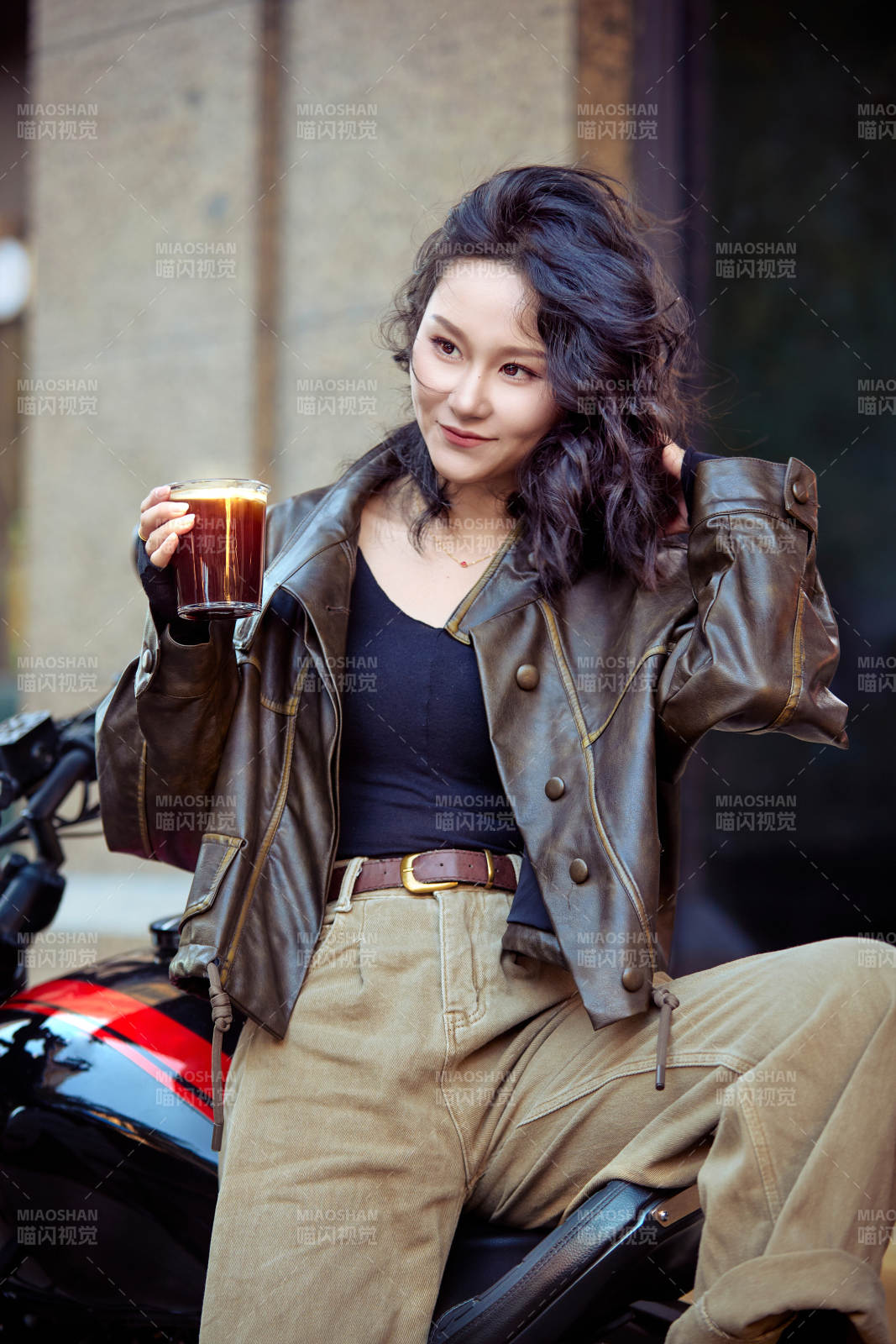 手拿冰美式咖啡坐在摩托上的亚洲美女图片