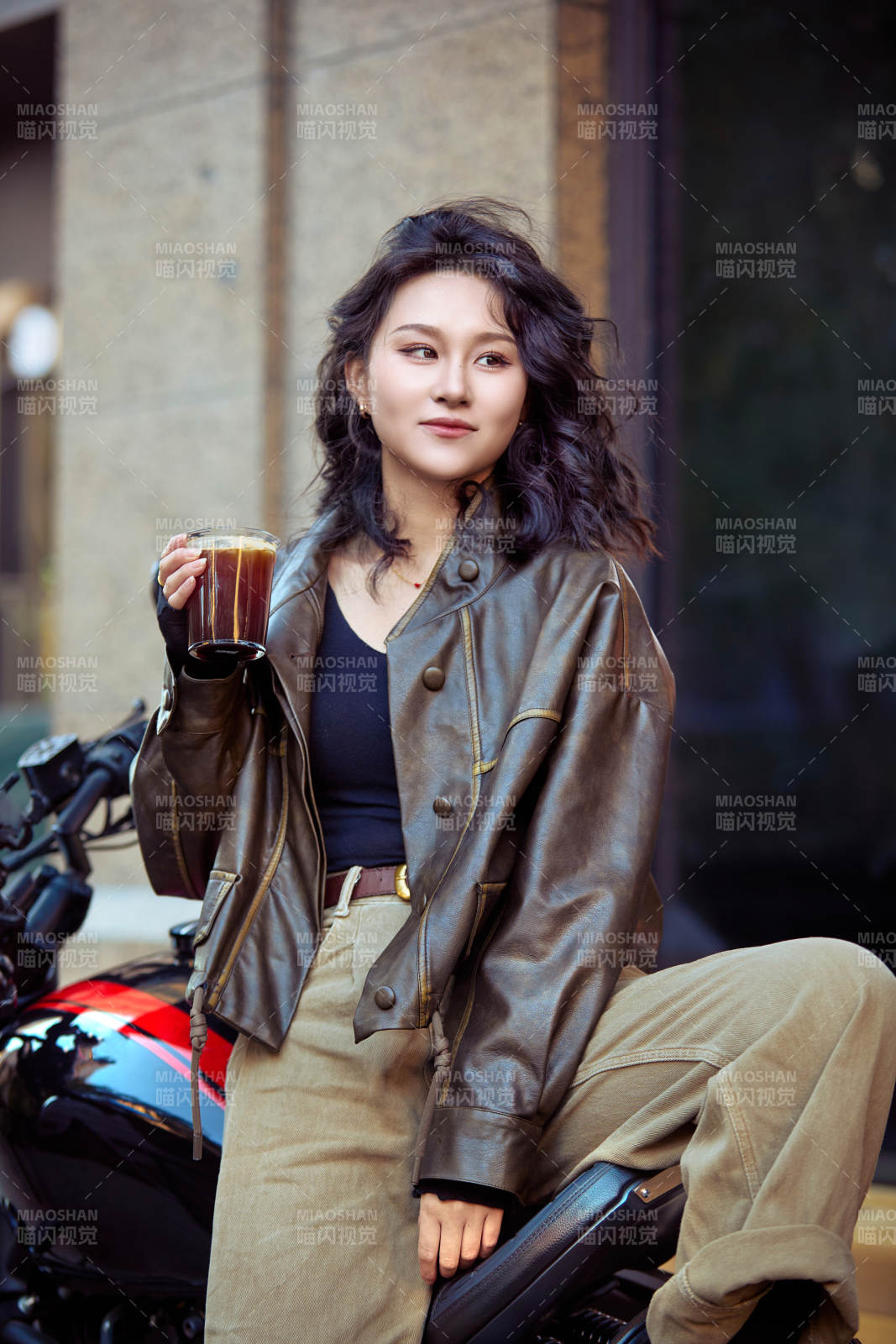 手拿冰美式咖啡坐在摩托上的亚洲美女图片