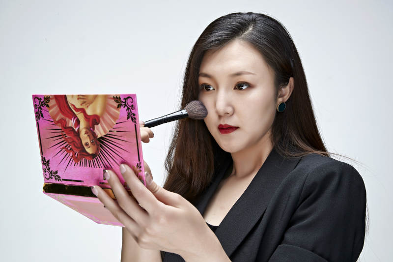 棚拍白色背景的亚洲青年女性化妆师图片