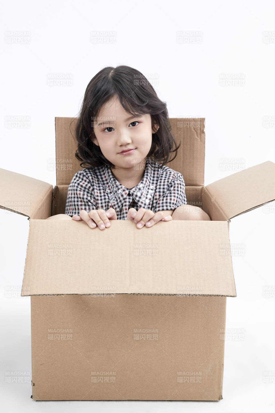 躲在纸箱中玩耍的调皮可爱亚洲小女孩儿童图片