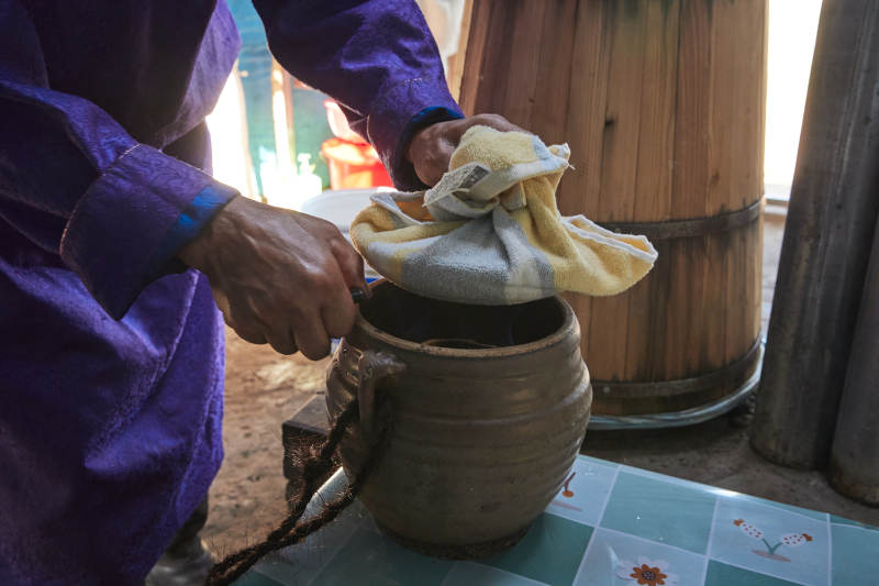 在蒙古包内用传统工艺蒸馏奶酒的过程图片