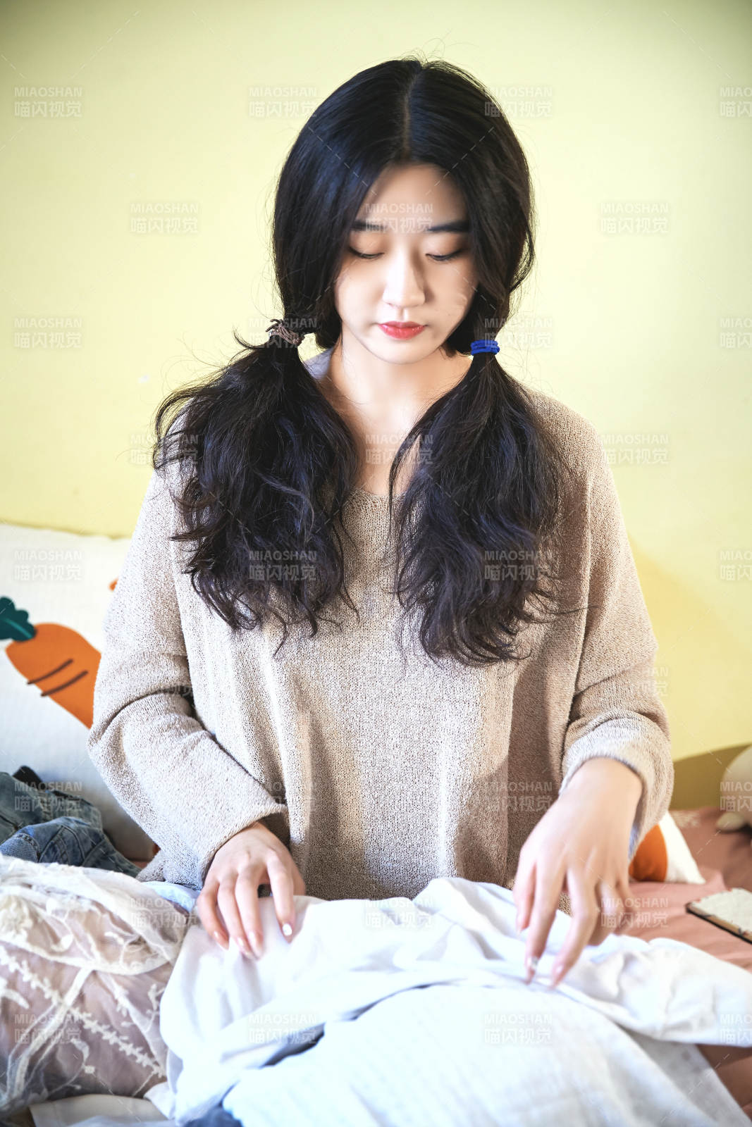 在沙发床上整理行装的年轻亚洲女性图片