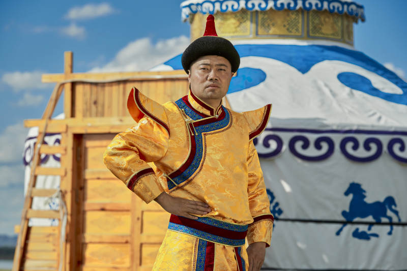 草原上蒙古包前身穿蒙古族传统服饰的男子图片