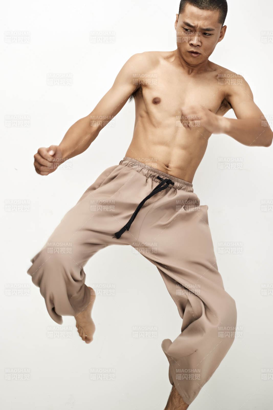 白色背景下演示自由搏击动作的亚洲功夫男性图片