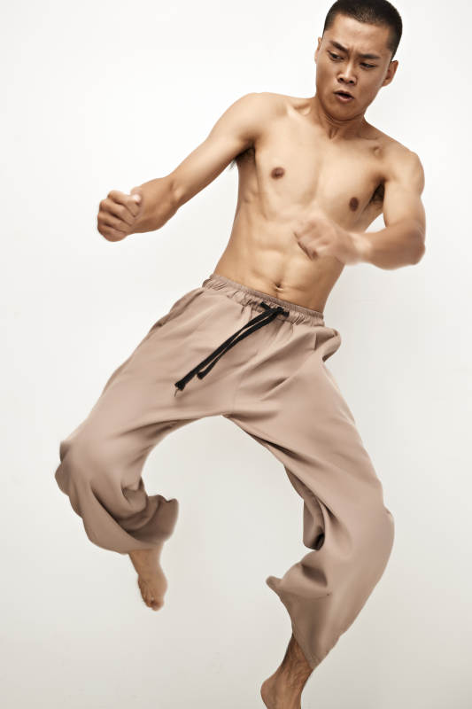 白色背景下演示自由搏击动作的亚洲功夫男性图片