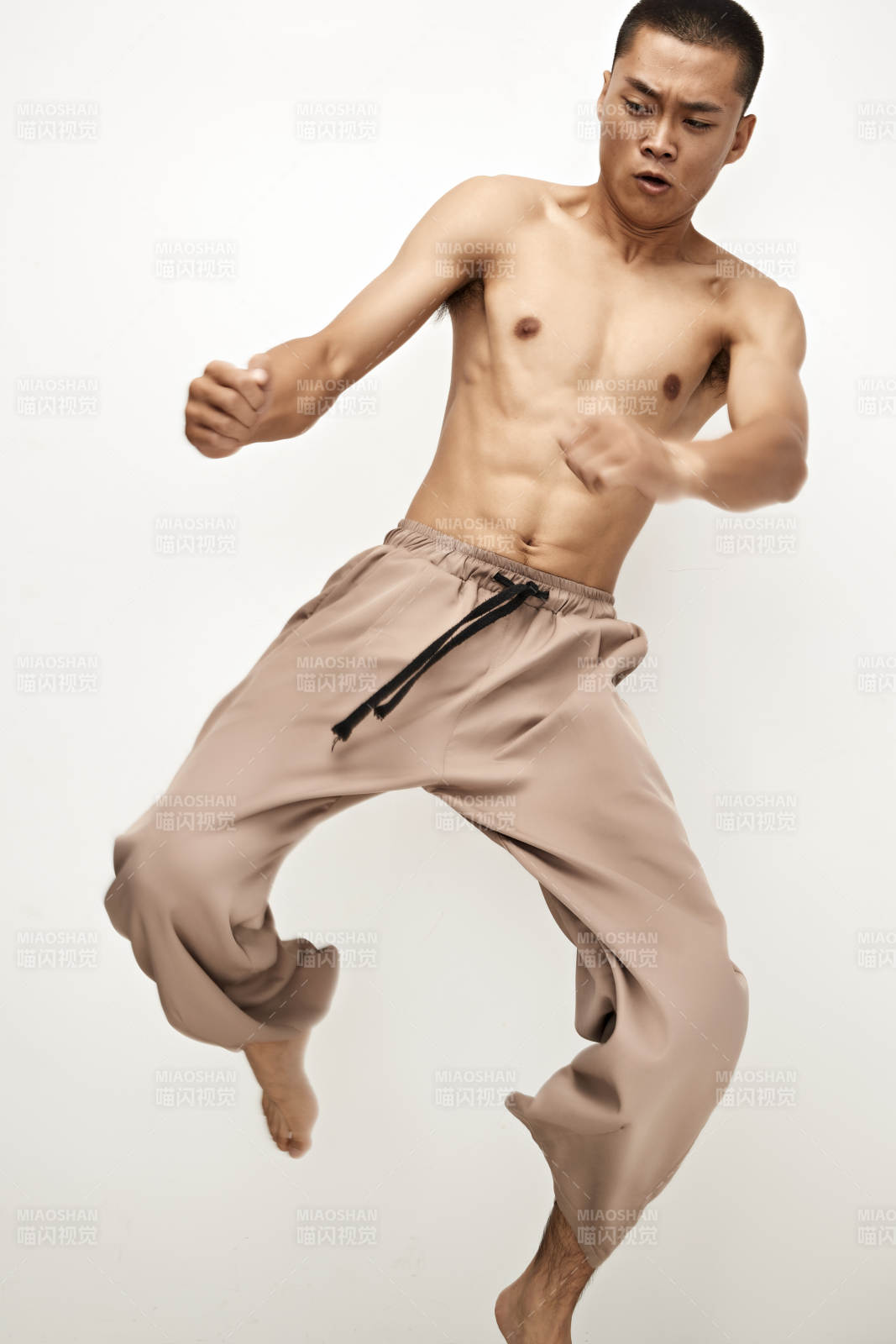 白色背景下演示自由搏击动作的亚洲功夫男性图片