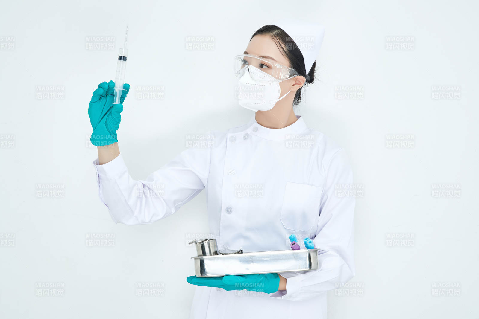 身穿护士服手抱化验托盘的年轻女护士图片