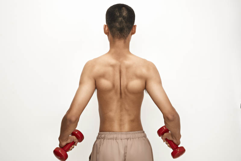 使用哑铃进行健身锻炼的亚洲男性图片