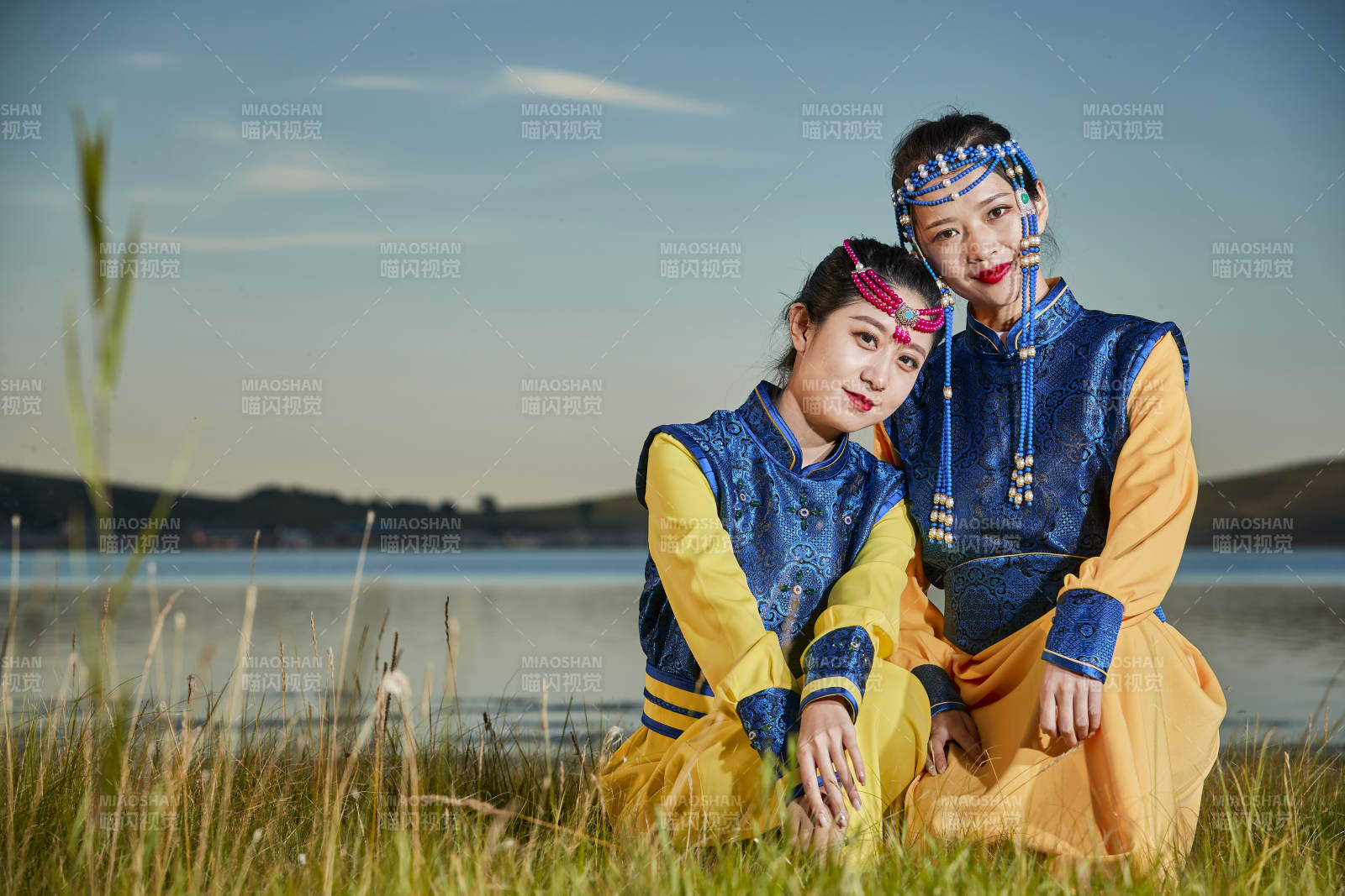草原上穿着蒙古族传统服饰的年轻蒙族姐妹图片