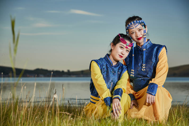 草原上穿着蒙古族传统服饰的年轻蒙族姐妹图片