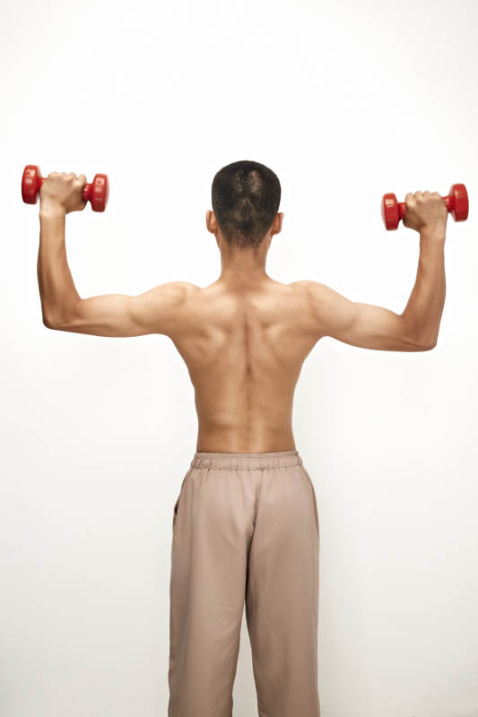 使用哑铃进行健身锻炼的亚洲男性图片