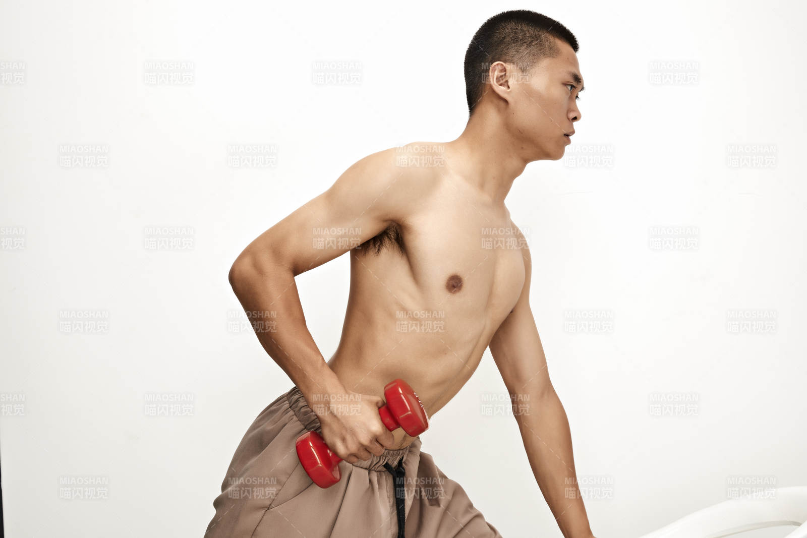 使用哑铃进行健身锻炼的亚洲男性图片