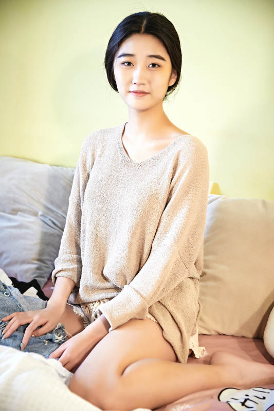 在沙发床上整理行装的年轻亚洲女性图片