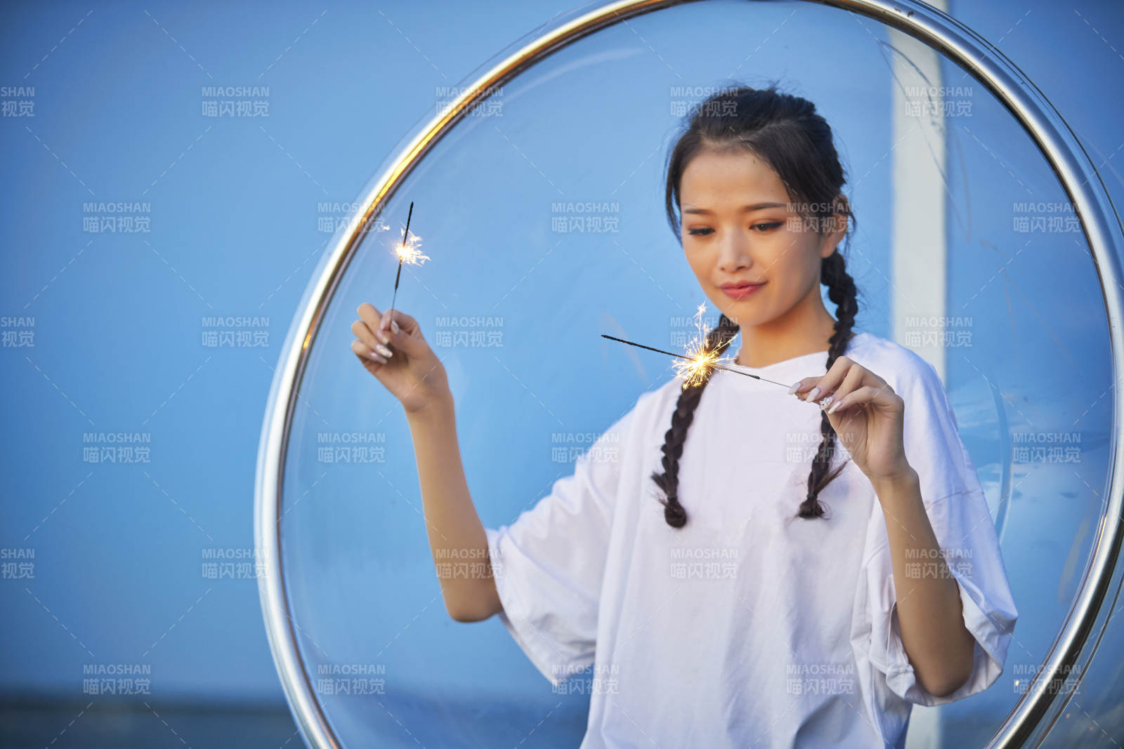 傍晚湖畔透明秋千上燃放仙女棒的可爱少女图片