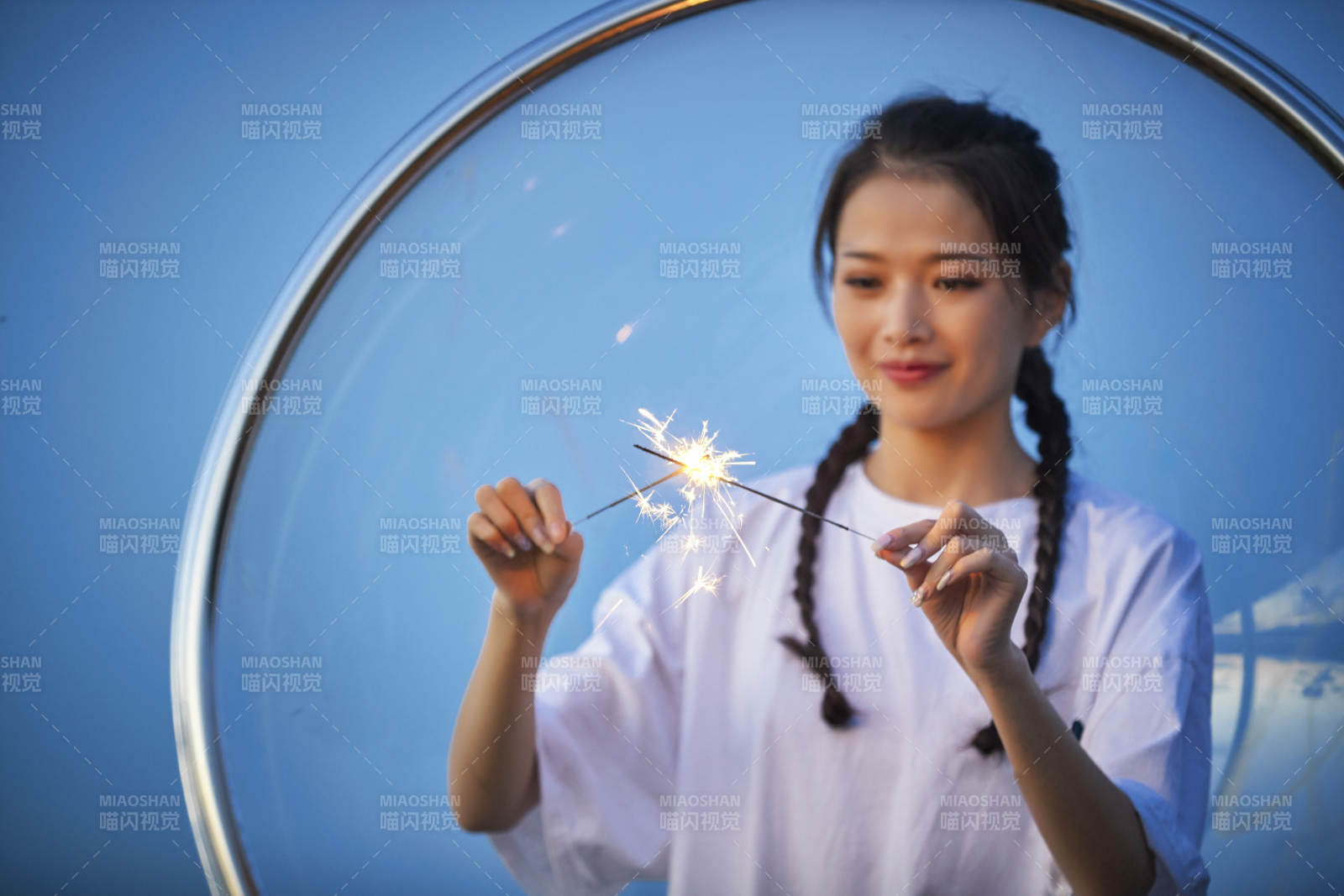 傍晚湖畔透明秋千上燃放仙女棒的可爱少女图片