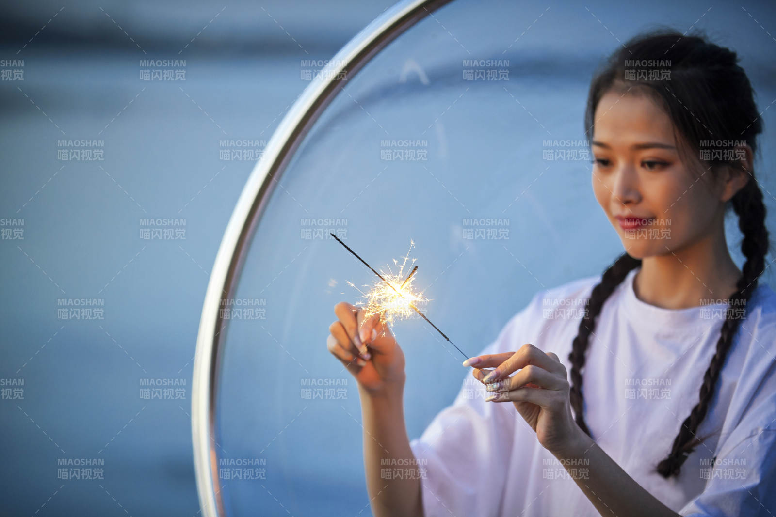 傍晚湖畔透明秋千上燃放仙女棒的可爱少女图片