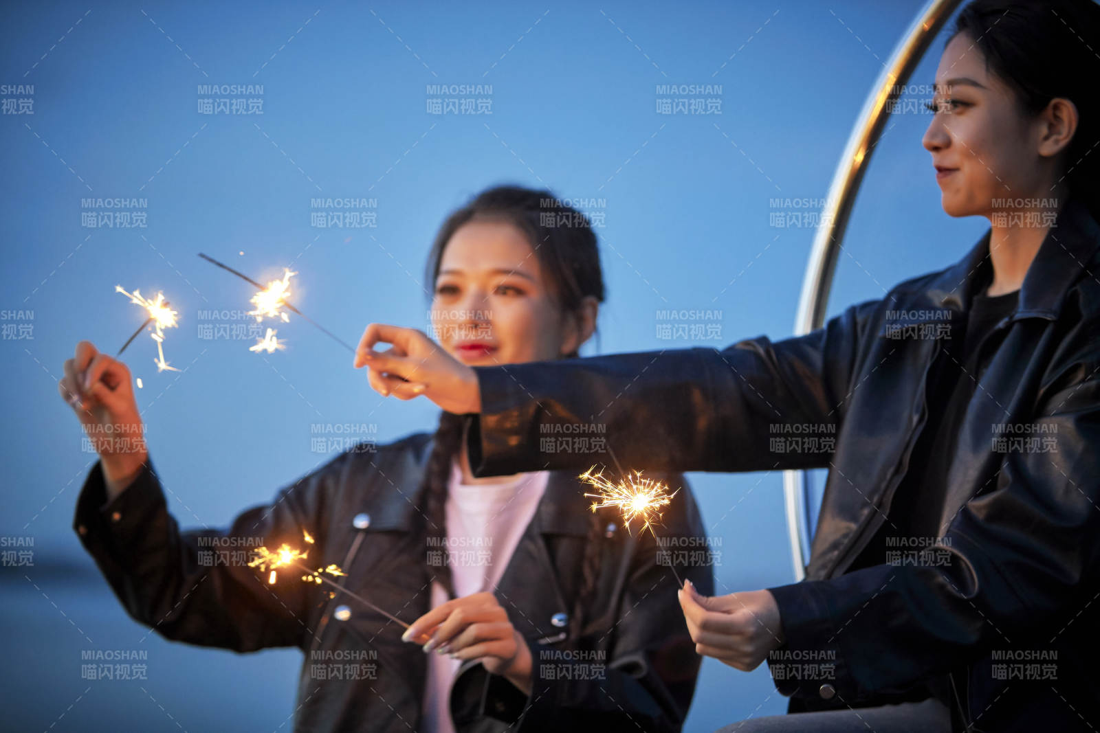 傍晚湖畔透明秋千上燃放仙女棒的可爱少女图片