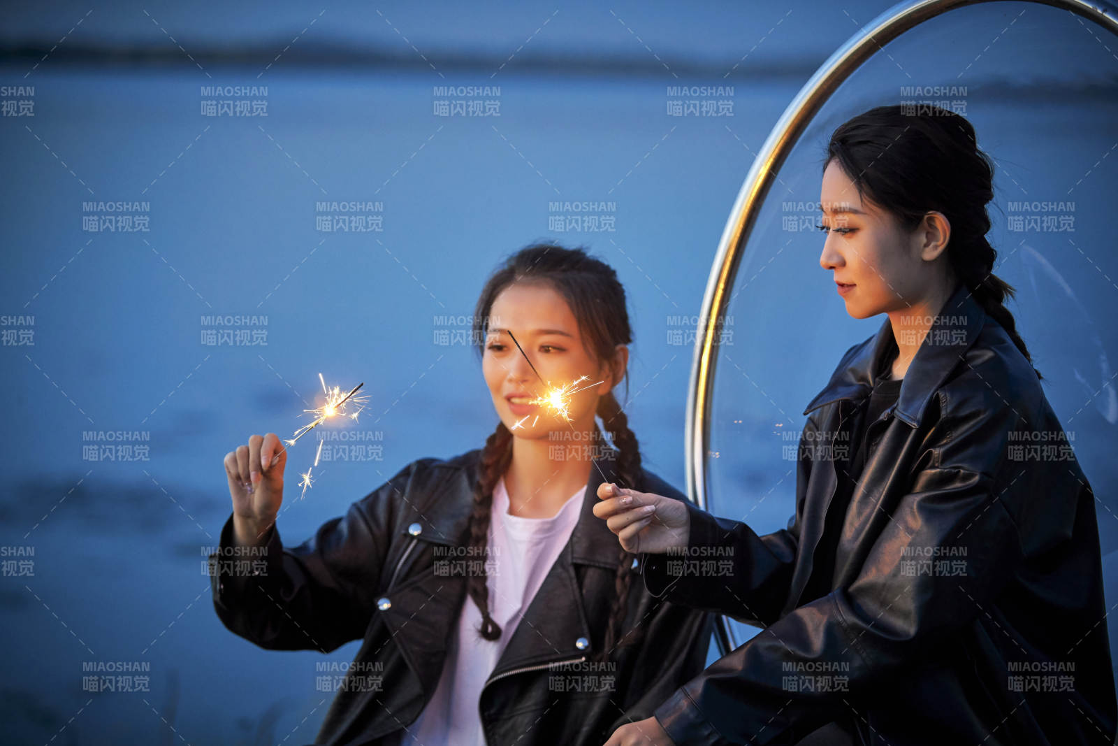 傍晚湖畔透明秋千上燃放仙女棒的可爱少女图片