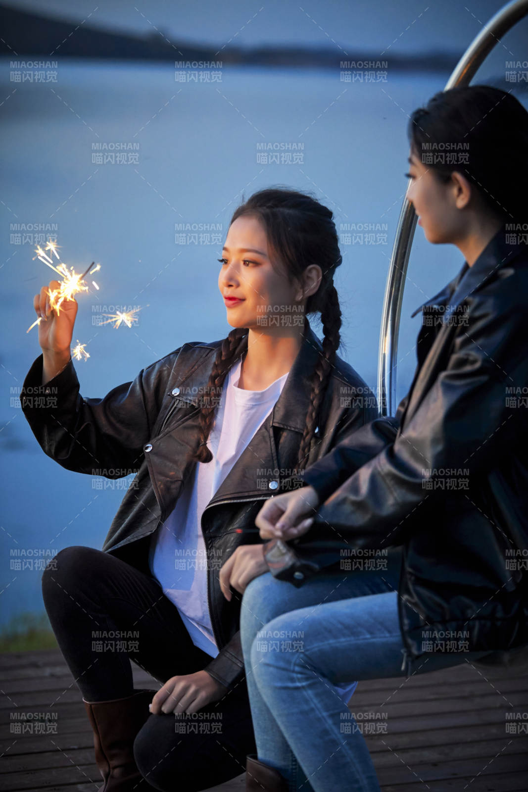 傍晚湖畔透明秋千上燃放仙女棒的可爱少女图片