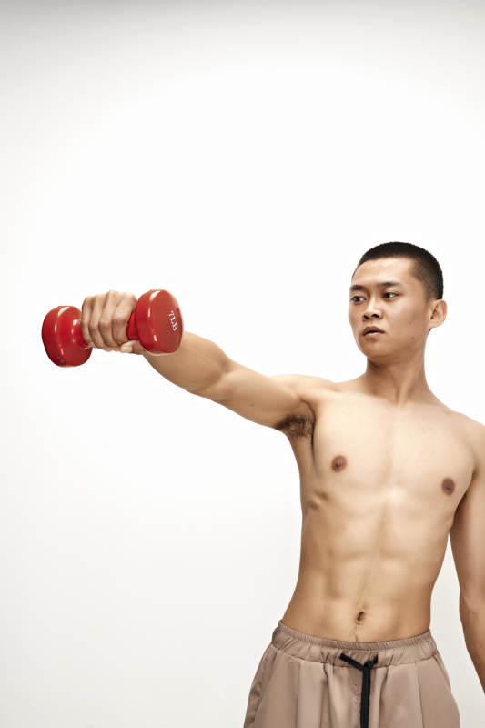 使用哑铃进行健身锻炼的亚洲男性图片