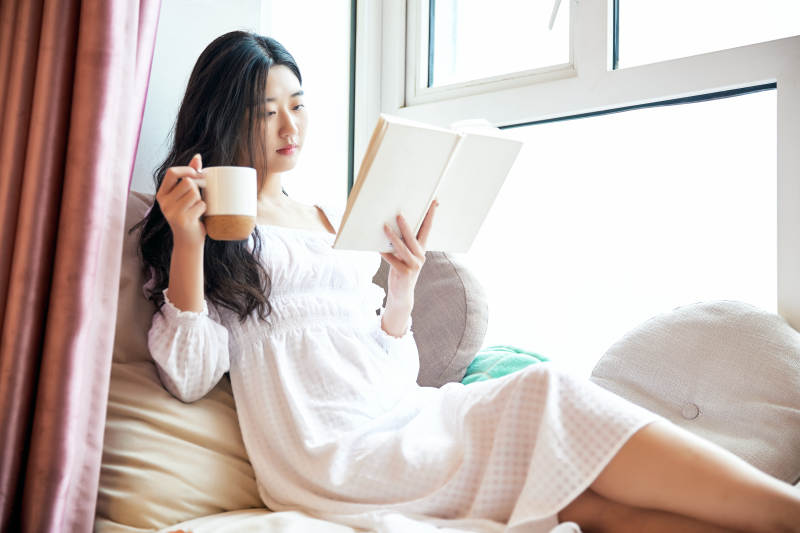 躺在舒适的飘窗上看书的女孩图片