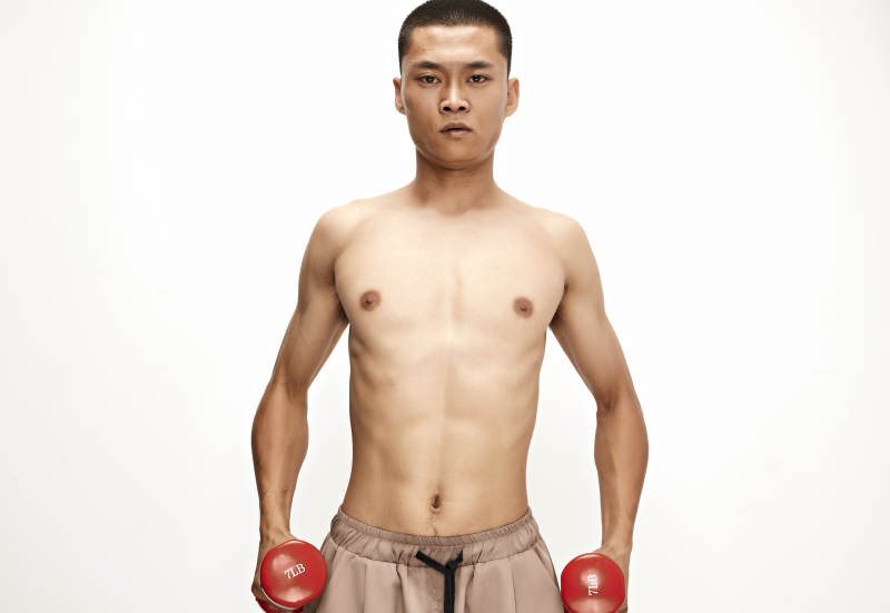 使用哑铃进行健身锻炼的亚洲男性图片