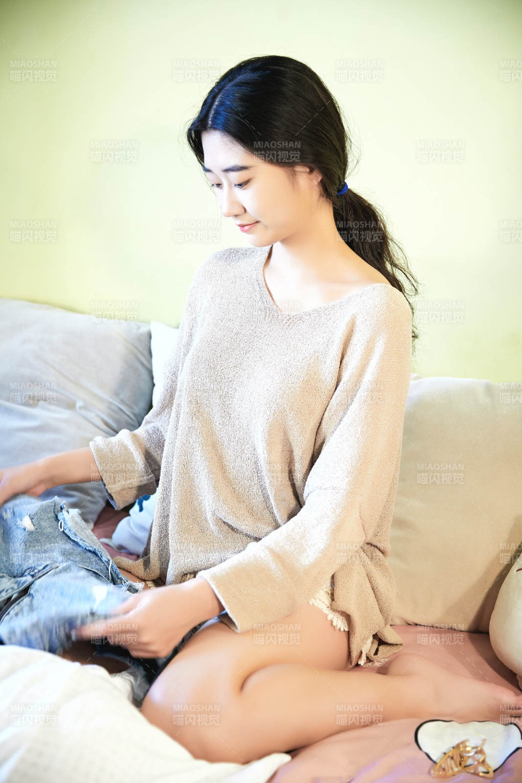 在沙发床上整理行装的年轻亚洲女性图片