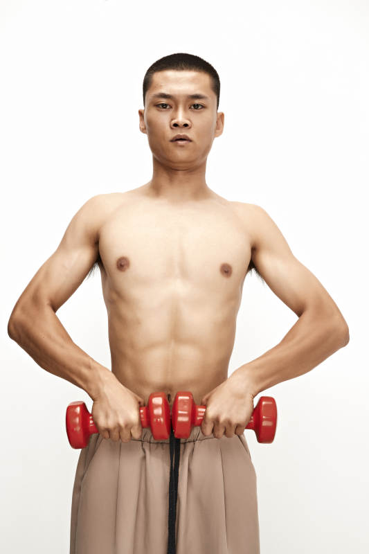 使用哑铃进行健身锻炼的亚洲男性图片