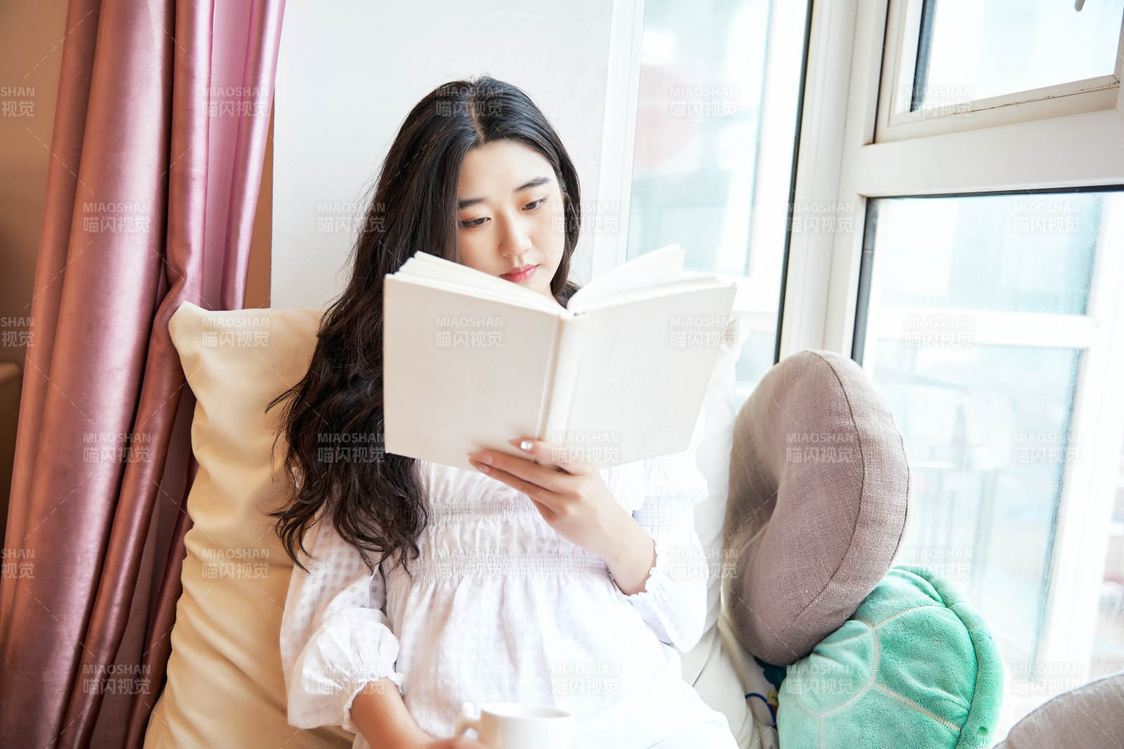 躺在舒适的飘窗上看书的女孩图片